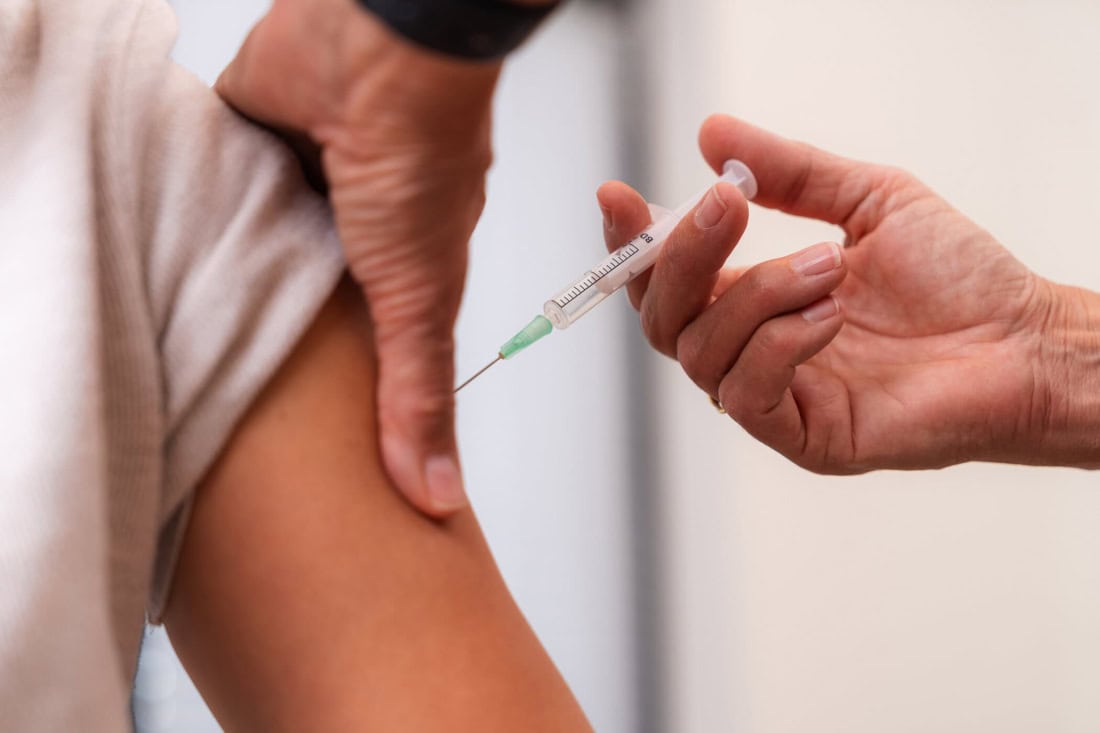 A person receives an injection in the arm for pneumococcal vaccination.